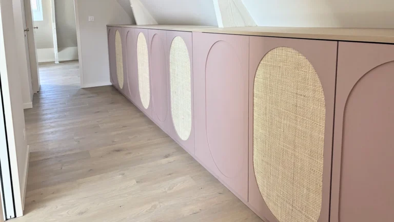 Rangements sous rampants en cannage à Saint-Lunaire — mélaminé vieux rose et décor chêne clair · cannage en rotin, vue d’ensemble