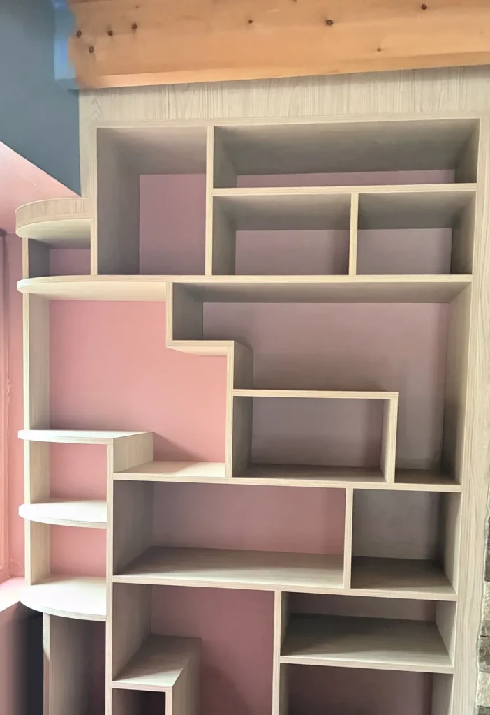 Bibliothèque asymétrique à Dinard — mélaminé décor chêne naturel et rouge brique, vue d’ensemble