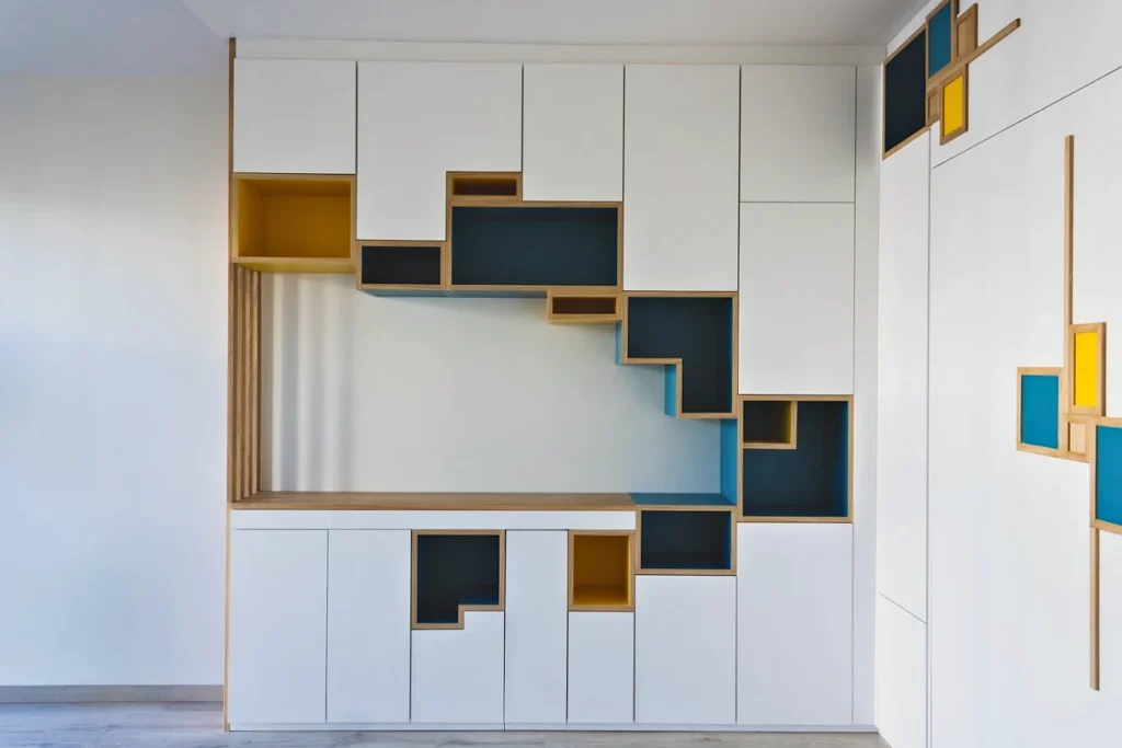 Bibliothèque composée de niches bleues, jaunes et bois, façon Mondrian
