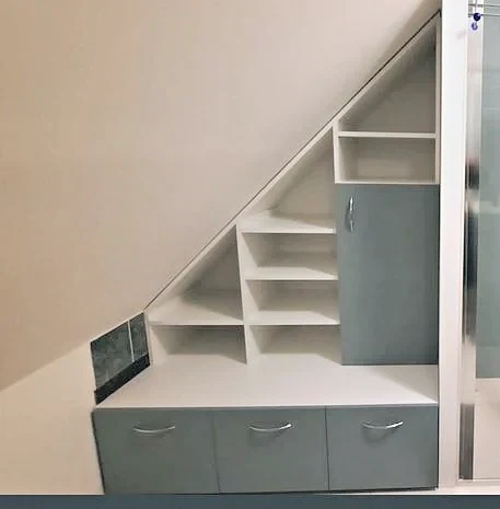 Rangement sur mesure aménagé sous un escalier